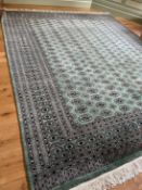 A large green ground Bokhara carpet.