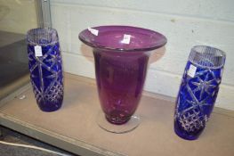 A large amethyst tinted glass vase and a pair of blue Bohemian glass vases.