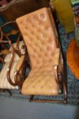 A brown button leather upholstered mahogany framed rocking chair.