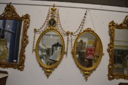 A very good pair of Adam revival gilt framed oval mirrors with urn finials, harebell swags, small