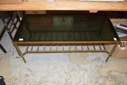 A brass and smoked glass coffee table.