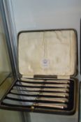 A cased set of six silver handled butter knives.