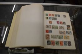 A green stamp album containing World stamps.
