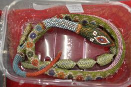 An articulated beadwork model of a snake and another similar.