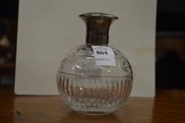 A silver topped cut glass scent bottle.