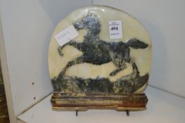 An unusual carved stone plaque depicting a prancing horse.