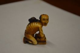 A Japanese Meiji period carved ivory small okimono of a rat catcher.