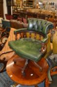 A green leather upholstered office swivel armchair.