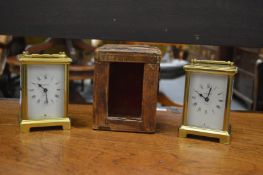 Two brass carriage clocks and an old carriage clock case.