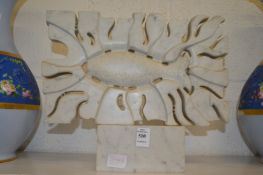 A carved marble sculpture depicting a fish.