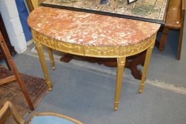 A good giltwood demi-lune console table with classical decoration and variegated rouge marble top.