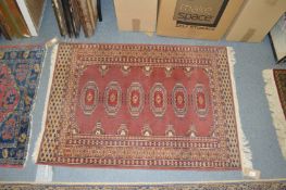 A small rust ground Bokhara rug.