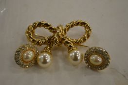 A bow shaped brooch and a pair of ear studs.