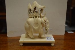 An early 20th century carved ivory group of an elephant with mahout, a howdah on its back containing