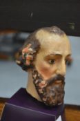 A painted plaster bust of a saint.