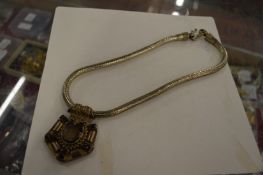 A large decorative pendant and chain.