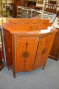 A good Sheraton revival painted satinwood serpentine fronted two door side cabinet.