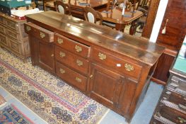 An 18th century oak dresser with three central graduated drawers flanked by a further pair of