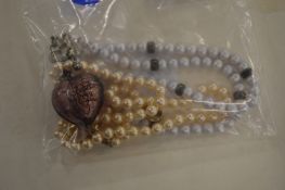 Two sets of pearl necklaces with heart shaped mounts.