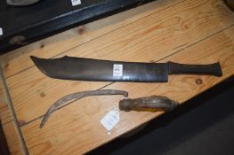 A carved wood model of a knife and a small sickle.