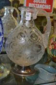 A good engraved and cut glass ewer or jug with silver mounted base.
