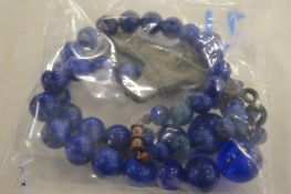 A blue bead necklace mounted with an old bronze cross.