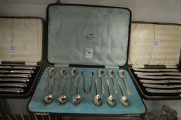 A cased of twelve silver coffee spoons with sugar tongs.