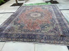 A large Persian carpet with floral decoration (some wear).