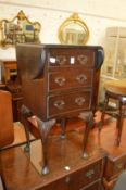 A mahogany drop flap three drawer bedside table.