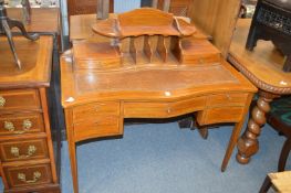 A Sheraton revival inlaid mahogany serpentine fronted writing table.