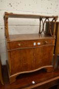 A small yew wood lamp table or side cabinet with a single drawer and a pair of doors.
