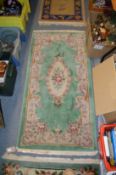 A small floral decorated green ground rug.