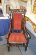 An 18th century walnut armchair with carved cresting rail, upholstered back panel and seat on barley