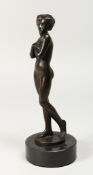 A GOOD BRONZE STANDING NUDE OF A YOUNG GIRL on a circular marble base. 10ins high.