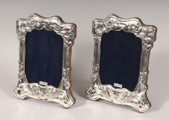 A PAIR OF SILVER UPRIGHT PHOTOGRAPH FRAMES. Butterfly design. 7ins x 5.5ins.