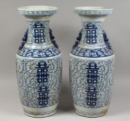 A PAIR OF CHINESE BLUE AND WHITE VASES. 23ins high.