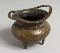 A CHINESE BRONZE TWO-HANDLED CENSER on three legs. Sixteen-character mark. 3.75ins diameter.