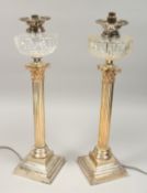 A GOOD PAIR OF CORINTHIAN COLUMN SILVER PLATED OIL LAMPS, each with a cut glass reservoir, converted