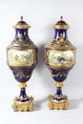 A SUPERB LARGE PAIR OF 19TH CENTURY SEVRES PORCELAIN URNS AND COVERS, rich blue ground with gilt