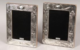 A PAIR OF SILVER UPRIGHT PHOTOGRAPH FRAMES. Deco design. 7ins x 5.5ins.