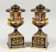 A SUPERB PAIR OF VIENNA BLUE GROUND URNS ON STANDS WITH COVERS, rich gilt ground painted with
