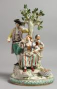 A GOOD MEISSEN PORCELAIN GROUP, a gallant, young lady and girl, with fruit and flowers around a
