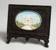 A GOOD INDIAN PAINTED IVORY OVAL PLAQUE of the Taj Mahal. 4ins x 3ins in a carved wood frame.