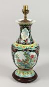 A CHINESE PORCELAIN LAMP with panels of flowers and birds on a wooden base. 19ins high.