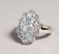 A SILVER AQUAMARINE CLUSTER RING.