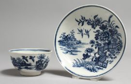 AN 18TH CENTURY WORCESTER TEA BOWL AND SAUCER, printed with a fenced garden in an island with