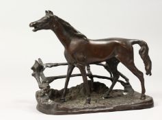 P. J. MENE A HORSE standing beside a fence. Signed. 9ins long.