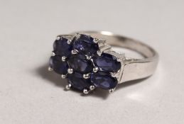 A SILVER SEVEN STONE SAPPHIRE RING.