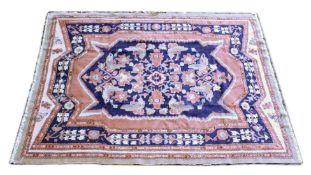 A PERSIAN CARPET, dark blue ground with stylised decoration, in a blue, beige border. 7ft 5ins x 5ft