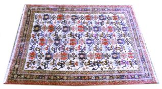 A PERSIAN CARPET, beige ground with allover stylised medallions. 7ft 10ins x 5ft 9ins.